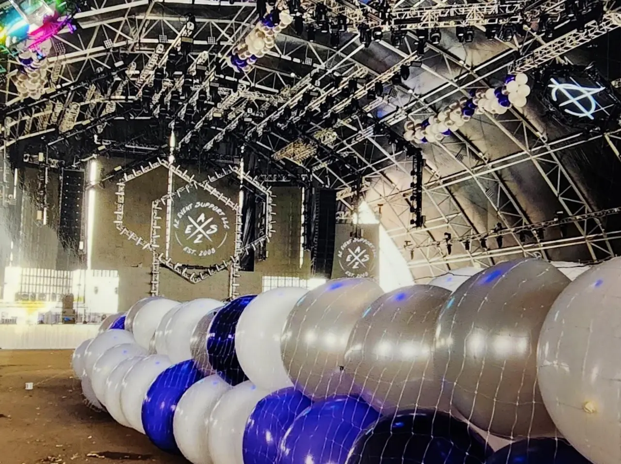 Concert stage with blue and white balloons.