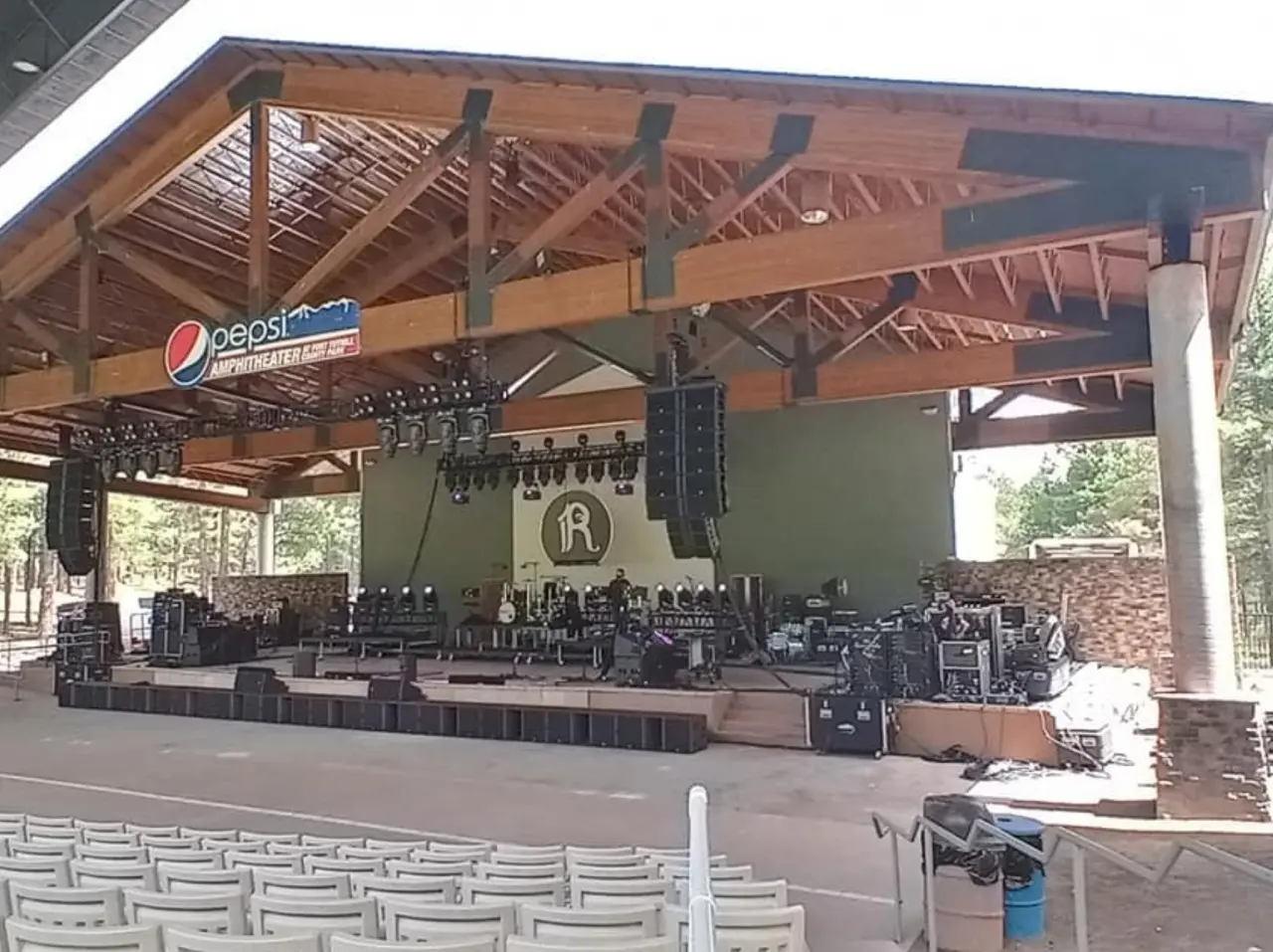 Outdoor concert stage with sound equipment setup.
