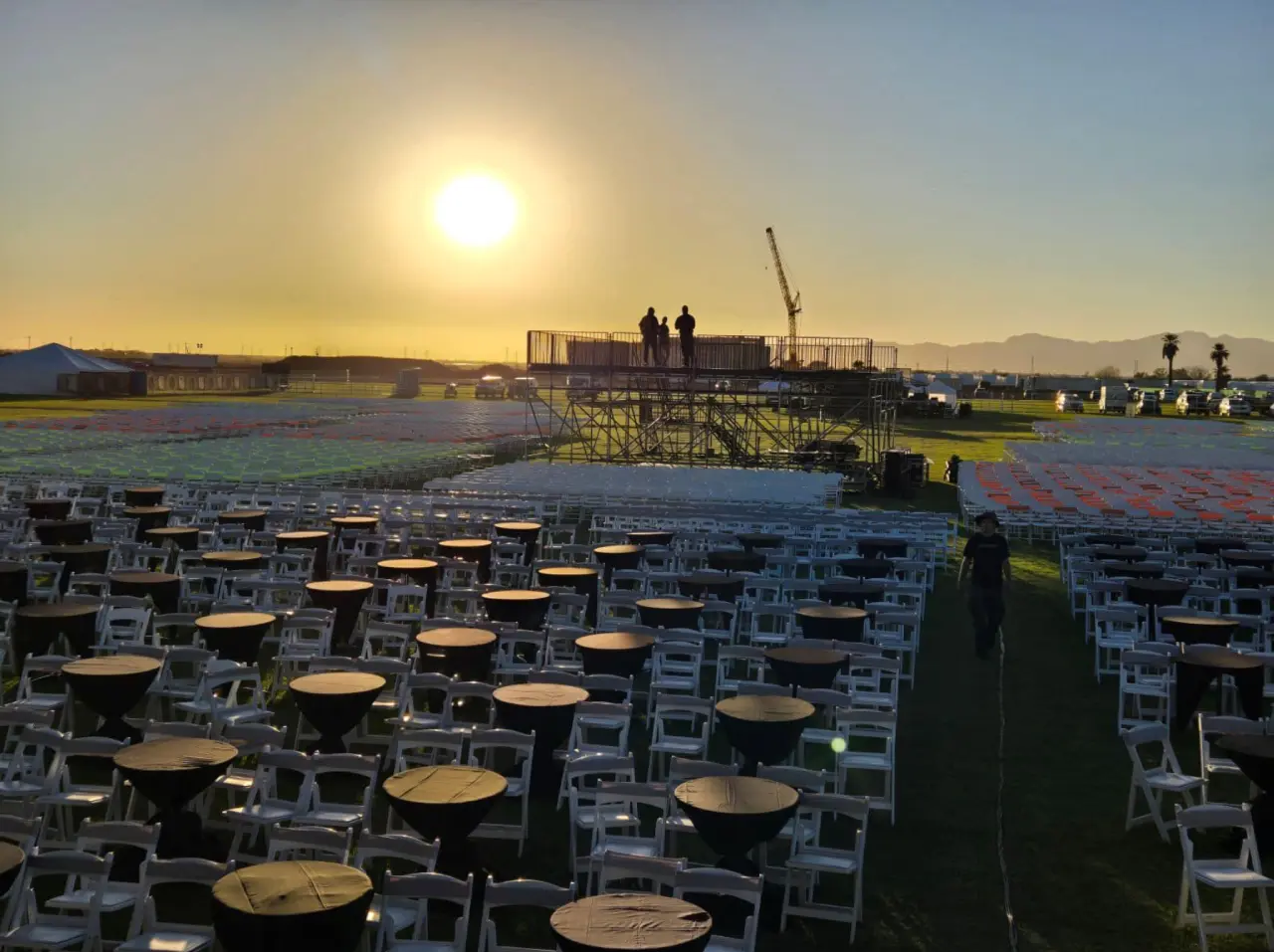 Outdoor event setup with sunset background.