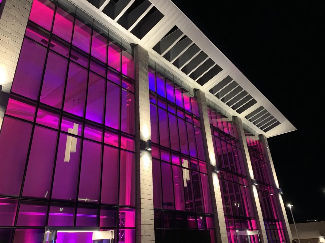 Modern building with pink illuminated windows.