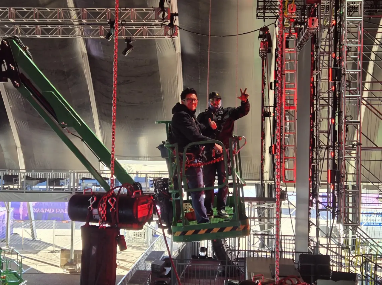 Crew members on a scissor lift, indoors.