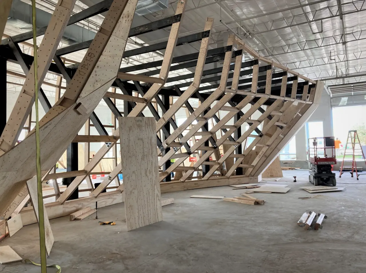 Wooden structure under construction in industrial space.
