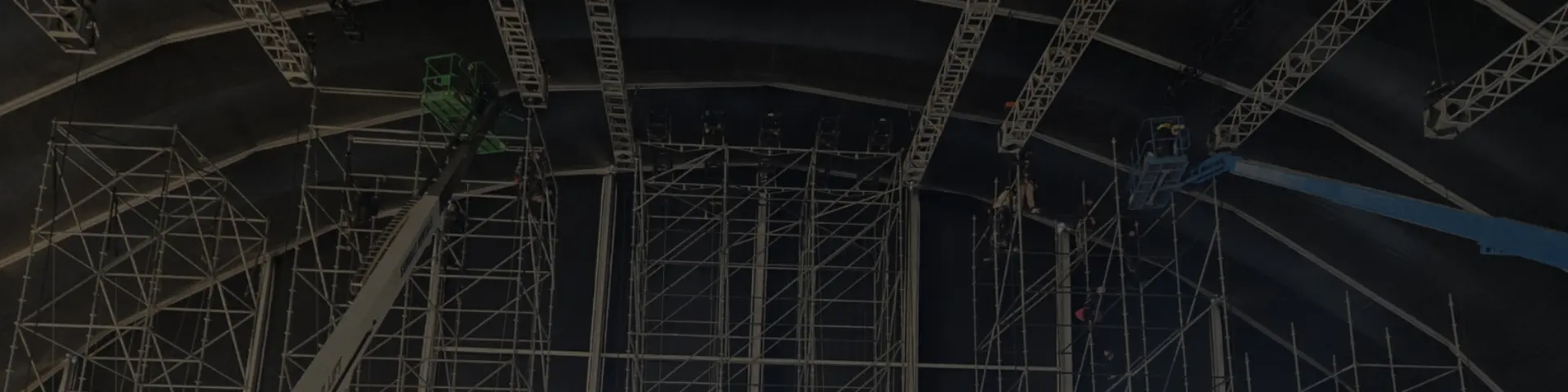A large empty metal scaffolding structure under a dark roof.