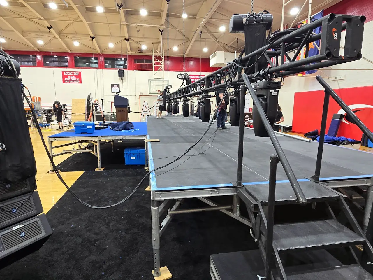 Stage setup inside a gymnasium with equipment.