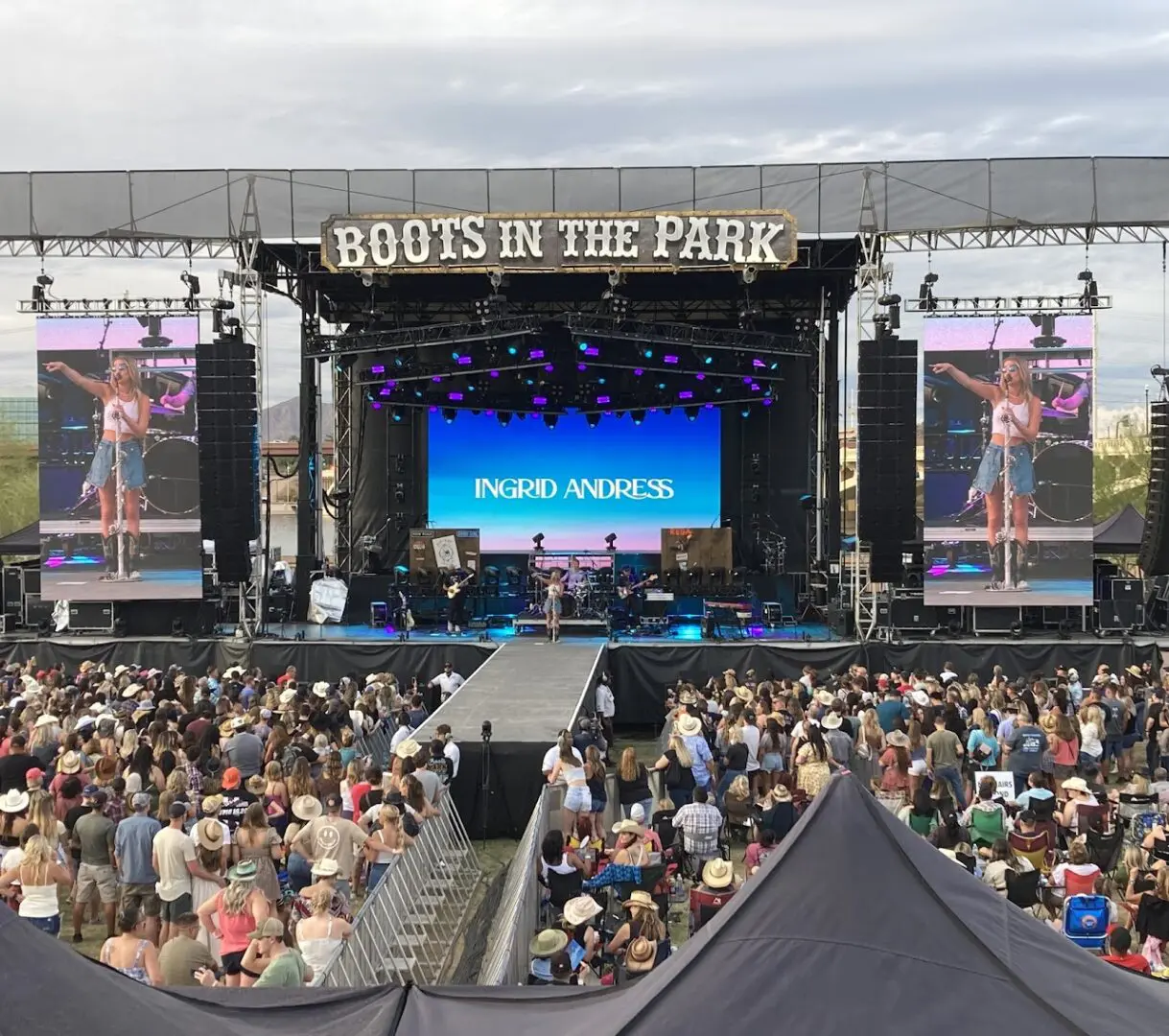 Outdoor concert stage with large crowd attending.